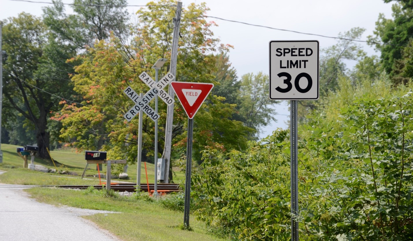 Figure 5. Example of vegetation obstructing pedestrian and driver view of the tracks at a passive crossing in Swanton, VT Image Credit: Volpe Center